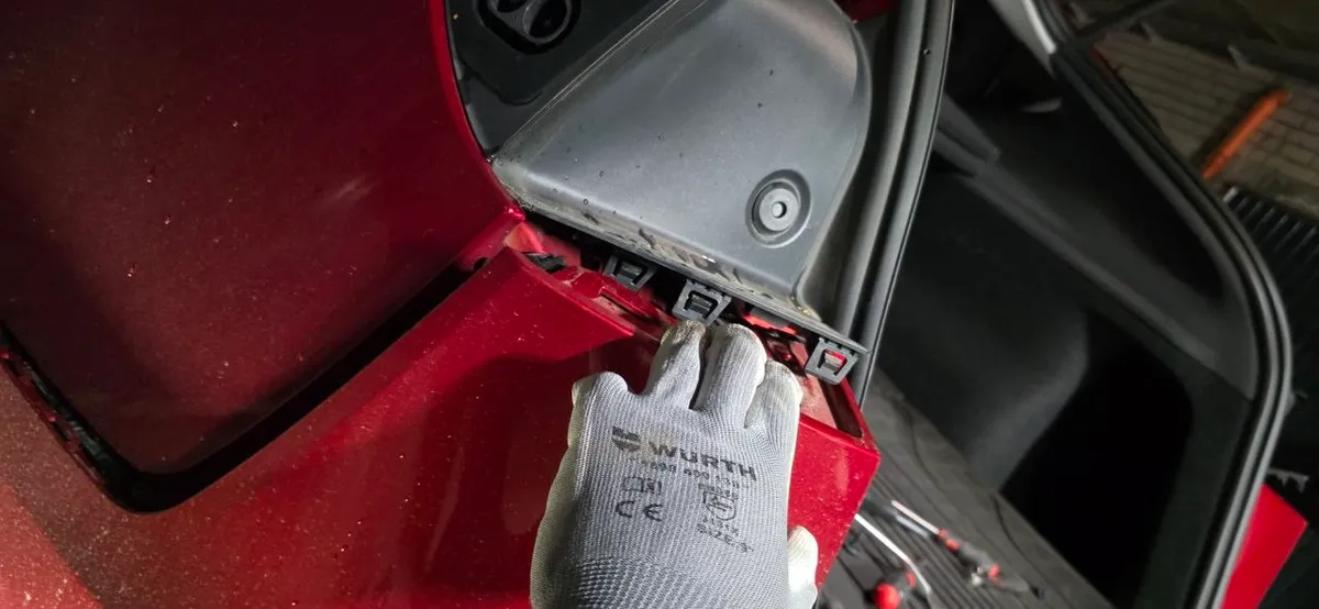Side clip rail beside the taillight opening with the bumper tabs visible