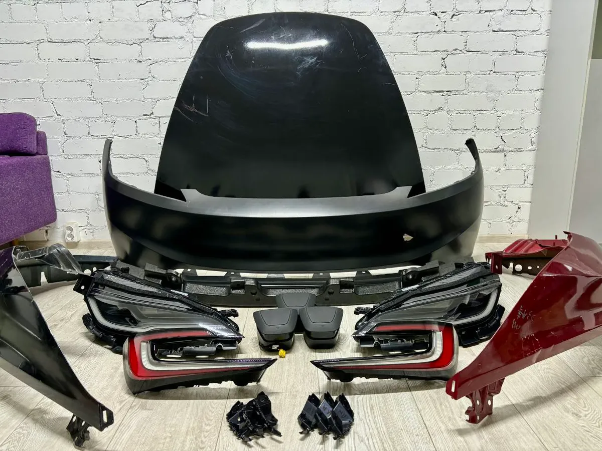 Tesla Model 3 Highland (2024+) front bumper, headlights, and taillights laid out for replacement